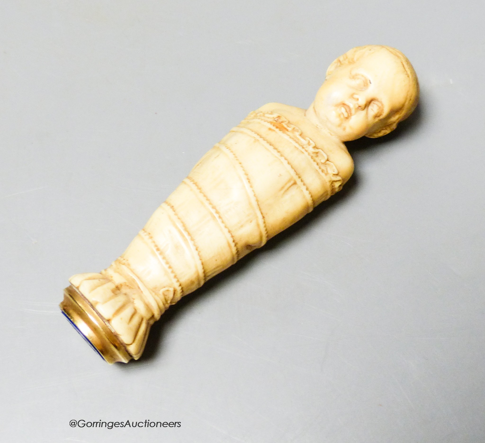 A 19th century or earlier carved ivory and lapis lazuli swaddling infant seal, length 10cm